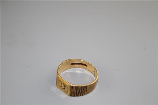 A modern 9ct gold and diamond chip set signet ring, with textured shoulders, size R/S, gross 3.9 grams.